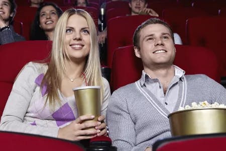 couple watch a movie while eating popcorn